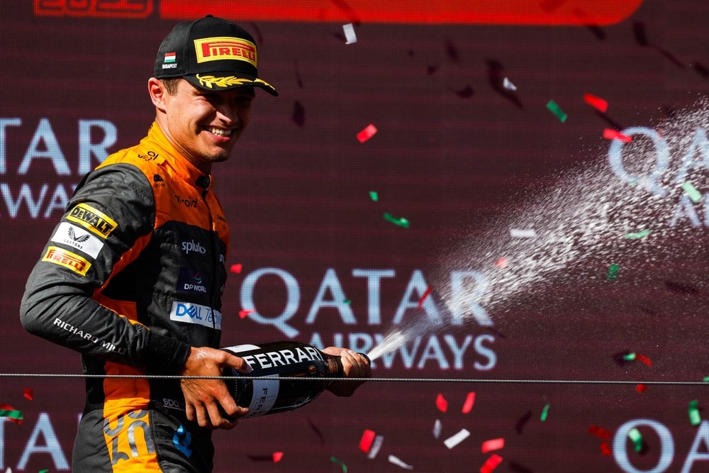 Lando Norris spraying champagne on the podium after finishing 2nd in the 2023 Hungarian Grand Prix