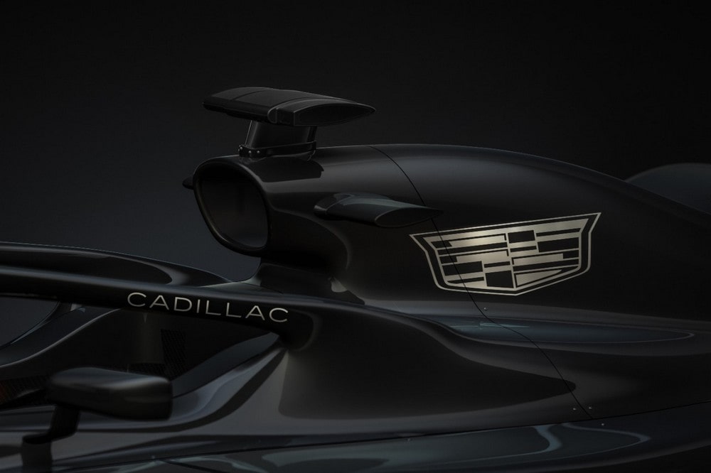 Close up 3/4 shot of black Formula 1 race car with white Cadillac logo on engine cover and halo.