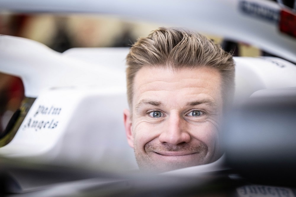 Nico Hulkenberg smiling while sitting in his Haas car