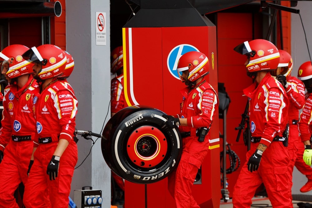 Ferrari mechanics carrying a Pirelli slick tyre