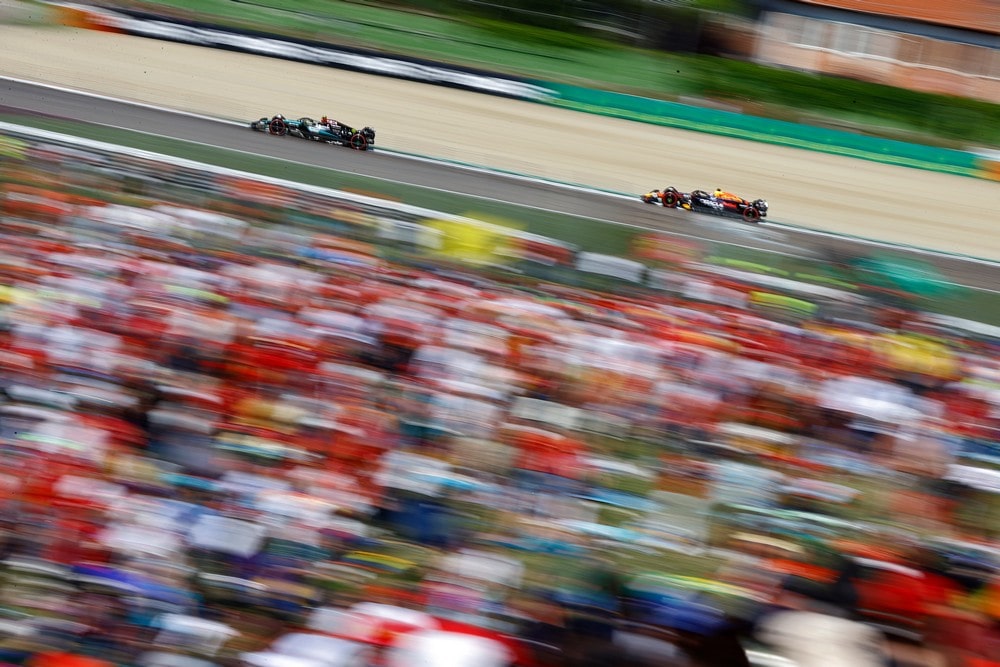 Lewis Hamilton and Max Verstappen race past a blurred crowd during practice for the 2024 Emilia Romagna Grand Prix