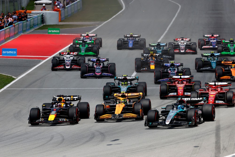 Max Verstappen, Lando Norris, and George Russell battle three abreast in the first corner of the 2024 Spanish Grand Prix