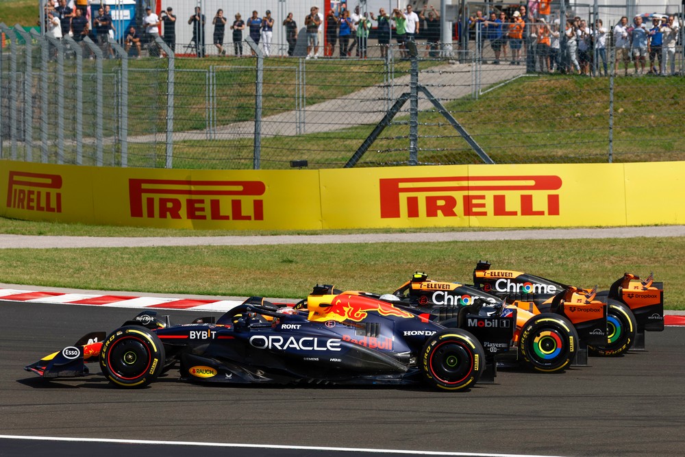 Max Verstappen, Lando Norris, and Oscar Piastri (from front to back) go three abreast in the first corner on the first lap of the 2024 Hungarian Grand Prix