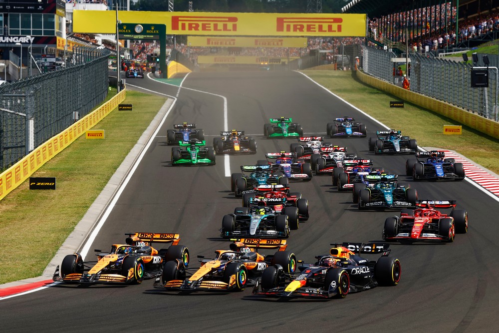 The race leaders enter the first corner three abreast on the opening lap of the 2024 Hungarian Grand Prix