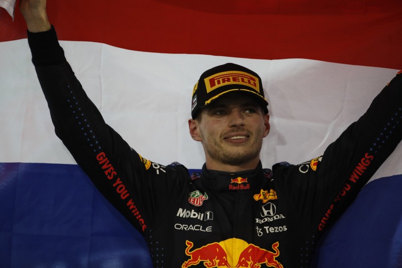 Max Verstappen holds up the Dutch flag after winning the 2021 Abu Dhabi Grand Prix