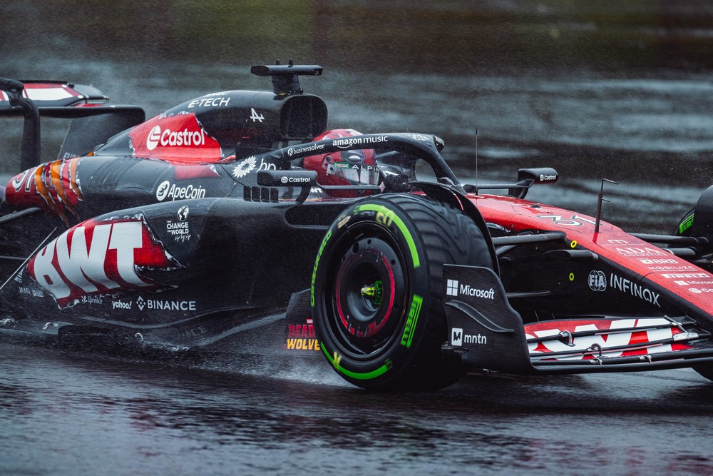 Esteban Ocon driving his Alpine car in a one-off Deadpool & Wolverine movie livery during a wet 2024 Belgian Grand Prix practice