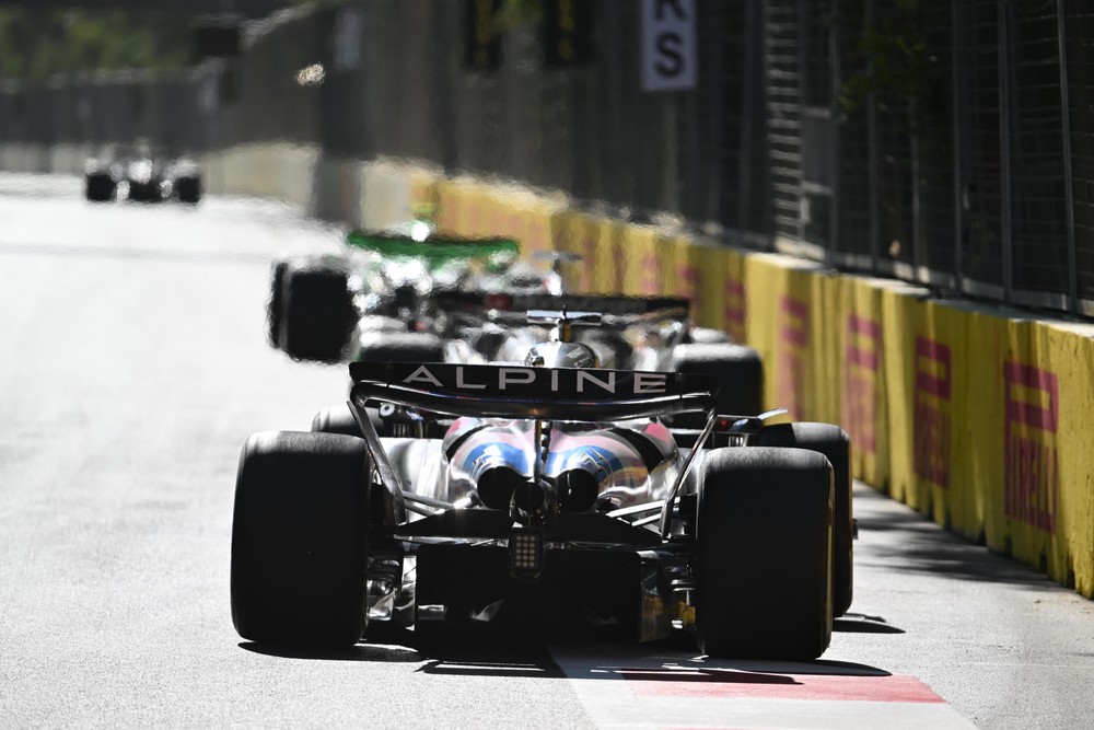 The rear of Esteban Ocon's Alpine as a group of cars race down the straight during the 2024 Azerbaijan Grand Prix