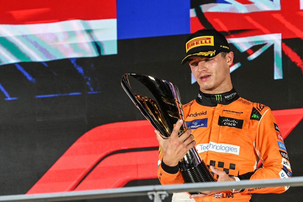 Lando Norris holds his P1 trophy on the podium after winning the 2024 Singapore Grand Prix