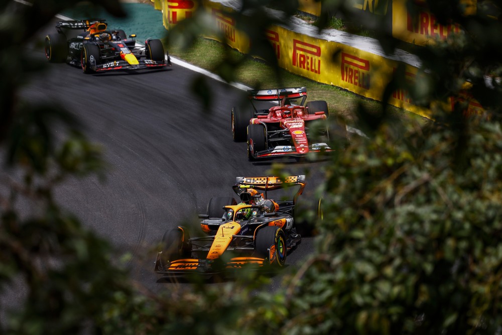 Lando Norris being closely pursued by Charles Leclerc and Max Verstappen while running P2 in the 2024 Brazilian Grand Prix sprint race