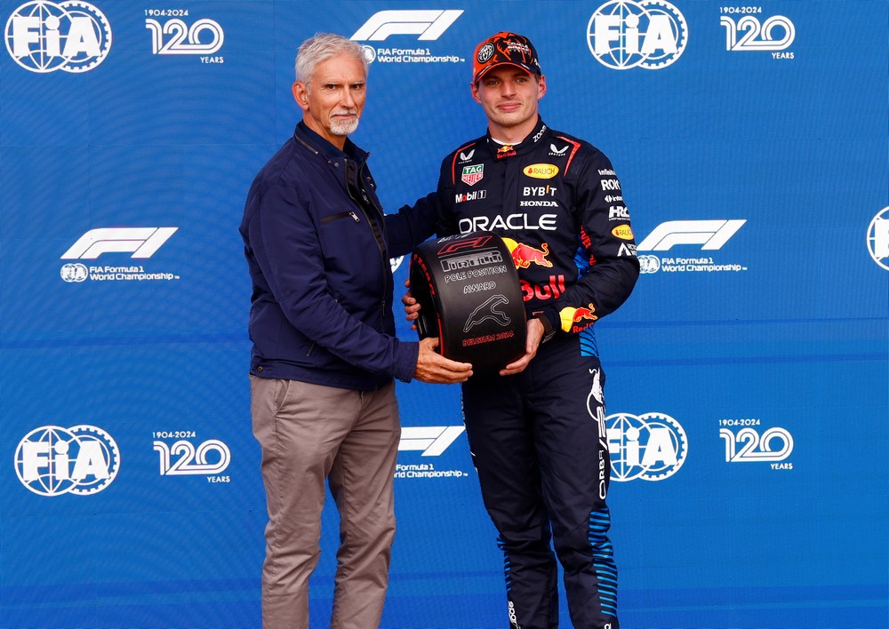 Damon Hill (left) awarding Max Verstappen (right) his pole position trophy after a wet 2024 Belgian Grand Prix qualifying session