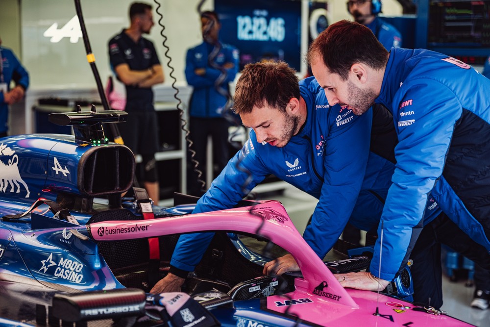 Pierre Gasly (left) shows Alpine team principal Oliver Oakes (right) the cockpit of his Alpine car during 2025 pre-season testing