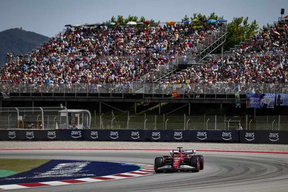 Charles Leclerc driving in the 2025 Spanish Grand Prix with a grandstand full of fans in the background